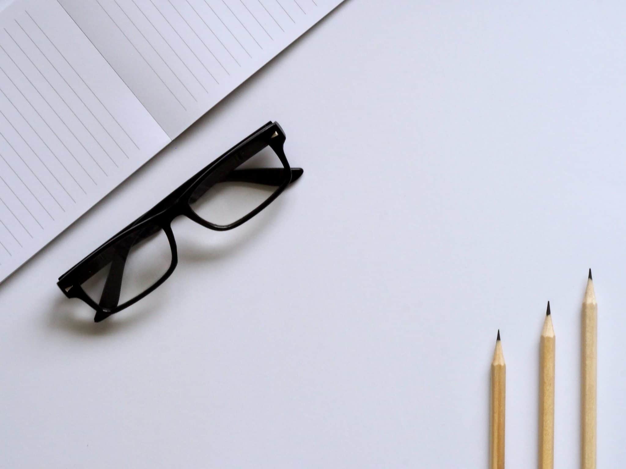 book and eyeglasses on desk