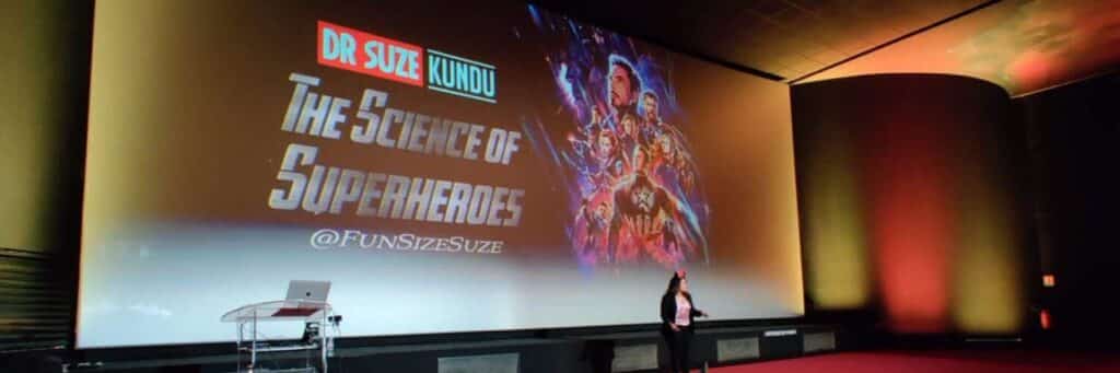 Suze giving a lecture on the Science of Superheroes in front of a large screen at Disneyland Paris