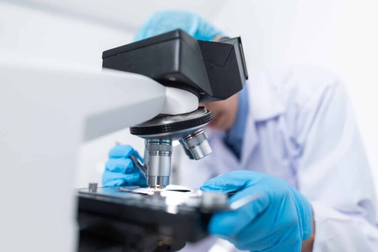 lab tech using microscope