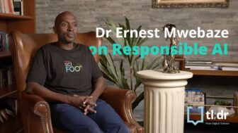 Ernest Mwebaze sits in a chair in a library