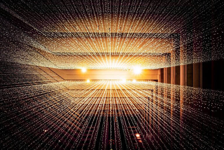 Abstract image of fairy lights with sun behind them