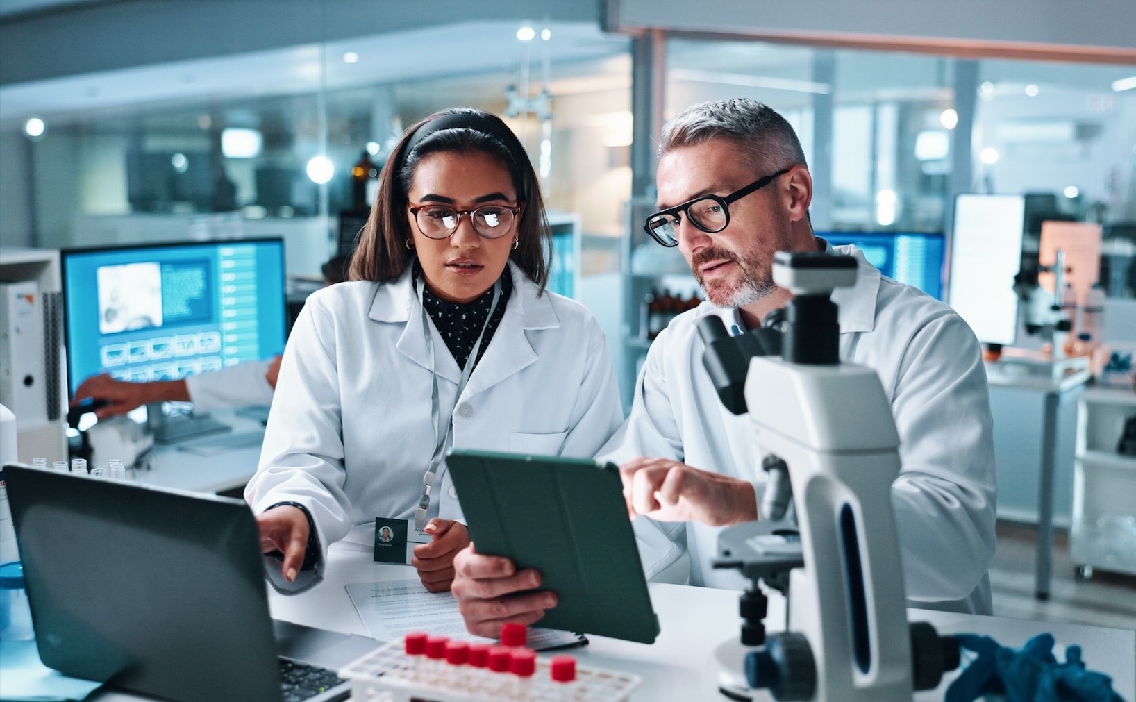 researchers in a pharma lab studying data - stock image