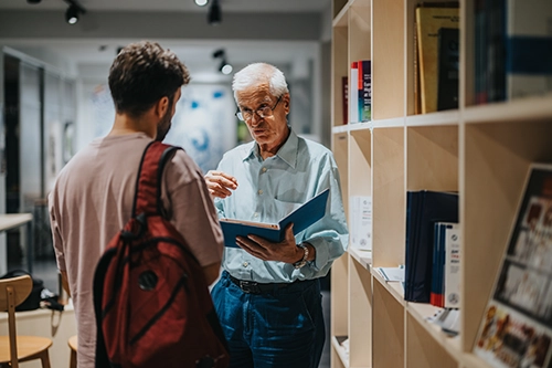 two researchers talking in library